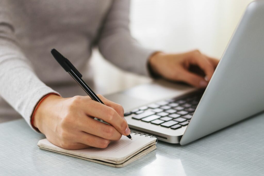 Person writing at computer